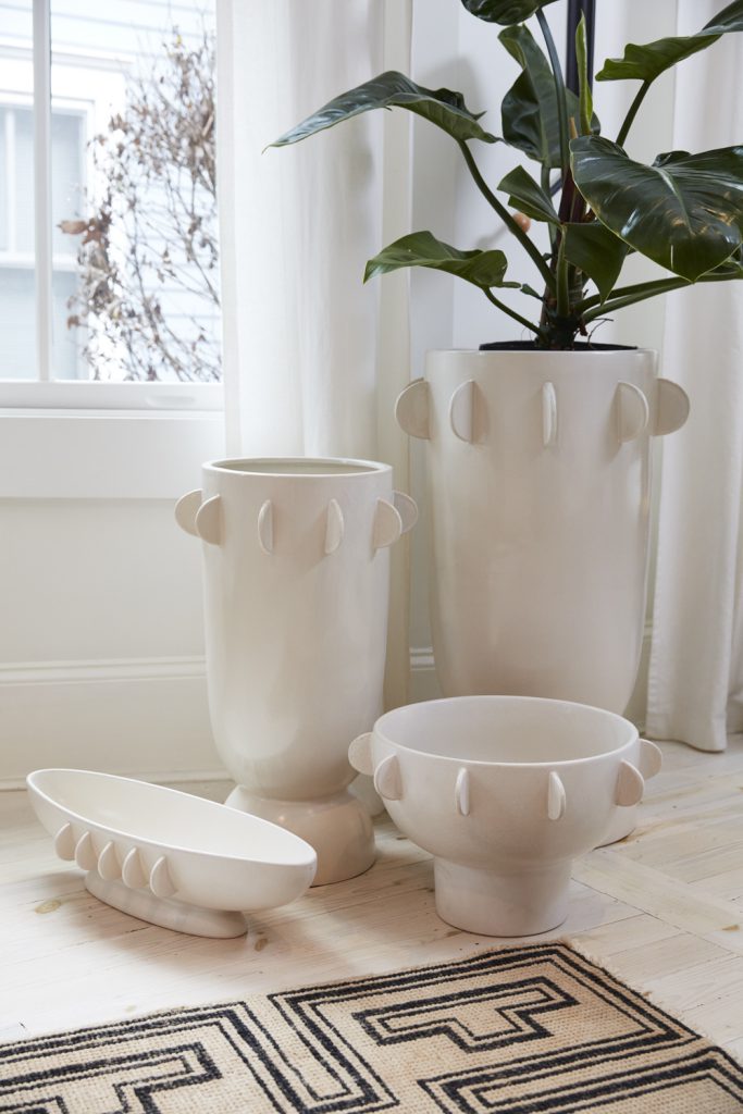 White large planters gracefully enhance the interior of a home, adding a touch of elegance and natural beauty. The spacious planters hold a variety of lush green plants, creating a vibrant and refreshing atmosphere within the living space.