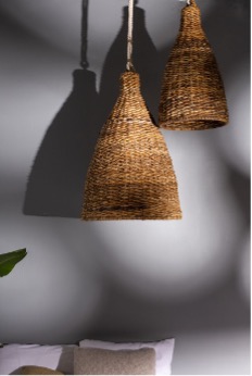 A moody image of the Canto Light Shade above a bed.