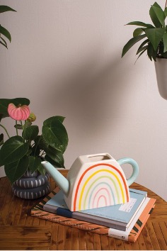 Over the Rainbow Watering Can atop a stack of books.