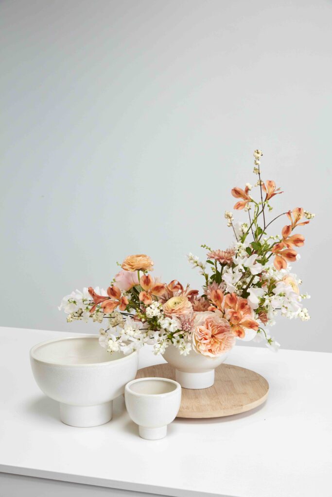 Accent Decor's Eco-Friendly Floral  Elijah Compote atop a white pedestal. 