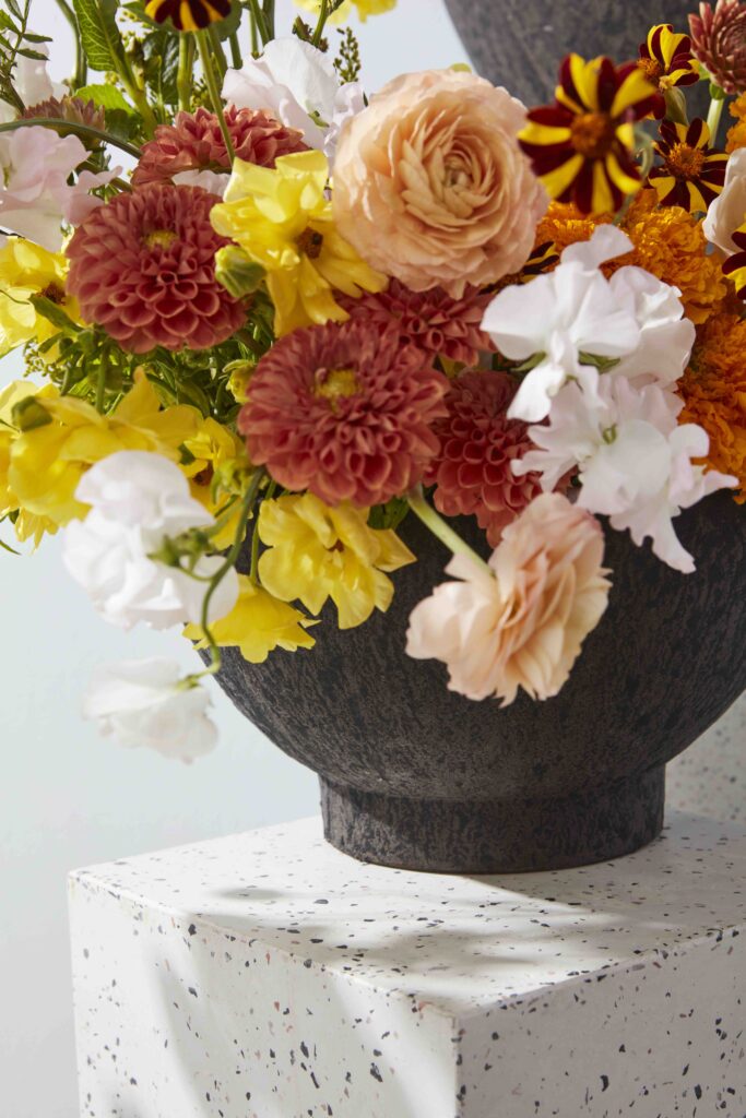 Accent Decor's Eco-Friendly Floral  Kuta Bowl atop a white pedestal. 