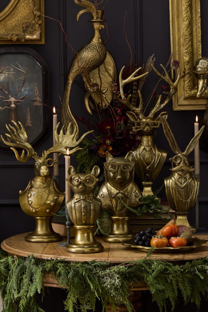 Eric and Eloise Busts displayed on a table surrounded by greenery and fresh fruit & veg.