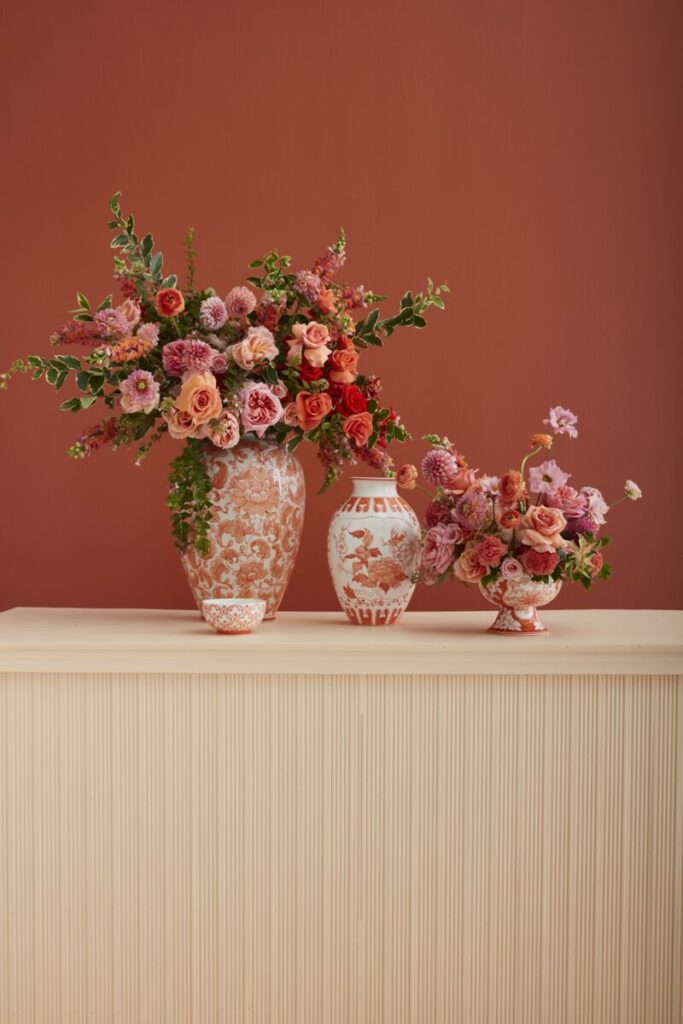 The Coral Eleanor Chinoiserie Vase Collection from Accent Decor, styled with fresh flowers on a tabletop.