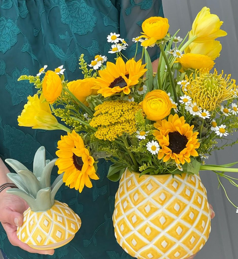 Image of a fruit-themed wholesale home decor vase shaped like a pineapple, styled with flowers.