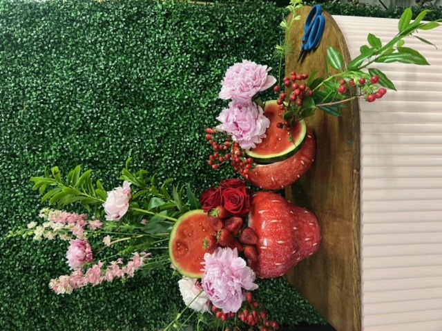 Group shot of a fruit-themed wholesale home decor vase shaped like strawberries, styled with flowers.