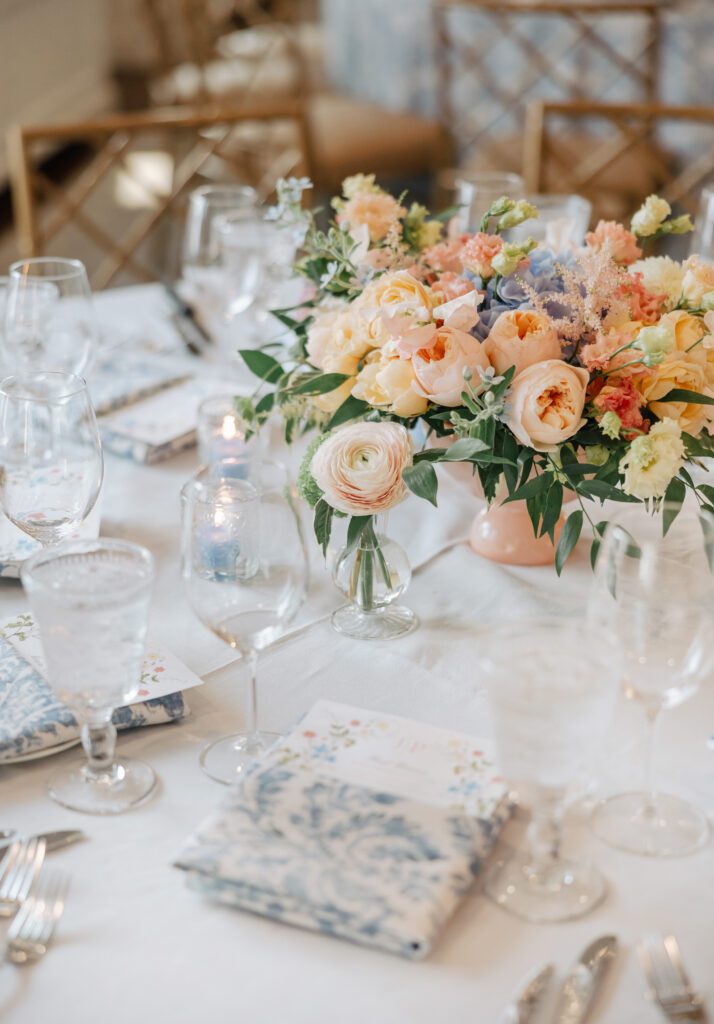 A close-up shot of a beautiful wedding reception centerpiece featuring peach and blue colored flowers.