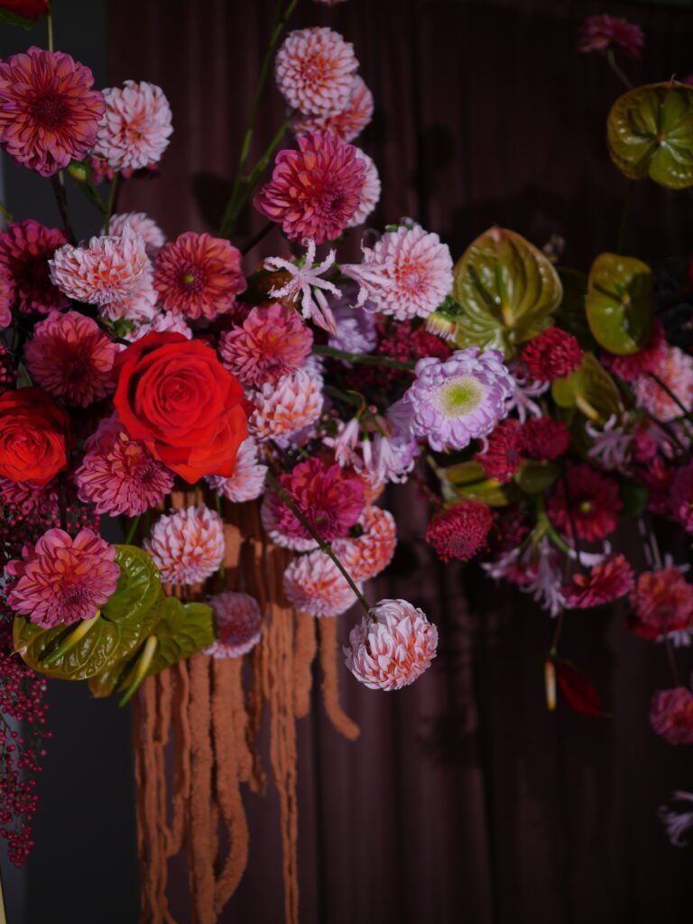 A close up image of lush & cascading flowers styled within Accent Decor's Tenuto Stand.