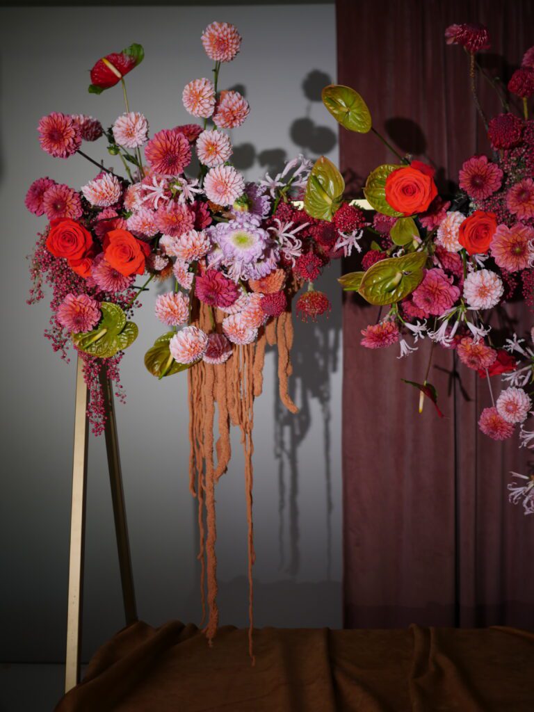 Accent Decor's Tenuto Stand, styled with lush & cascading flowers, atop a table.