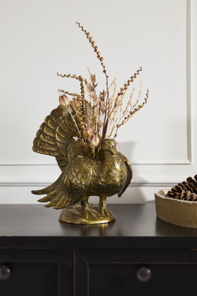 Accent Decor's Autumn Turkey Vase styled with dried florals atop a table. 