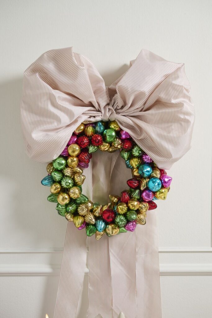 Accent Decor's Retro Bauble Wreath hung on a white wall. 