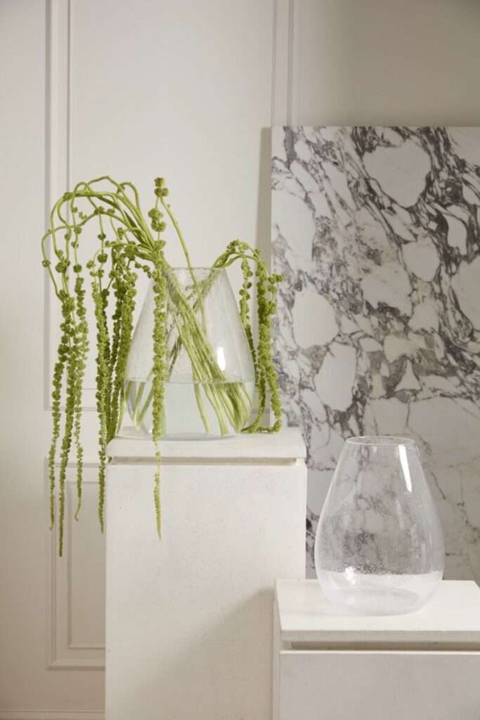 Accent Decor's Calista Vase, a large glass vase, artfully styled with florals atop a marble table.