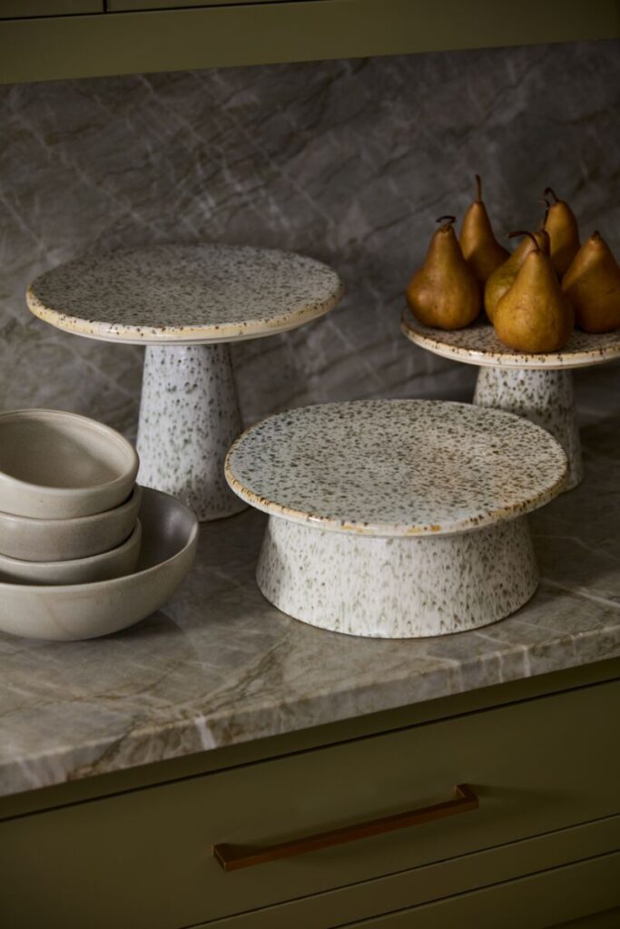 An image of the Starling Serving Stand atop a kitchen counter with complementary bowls offered by wholesale home decor provider, Accent Decor.