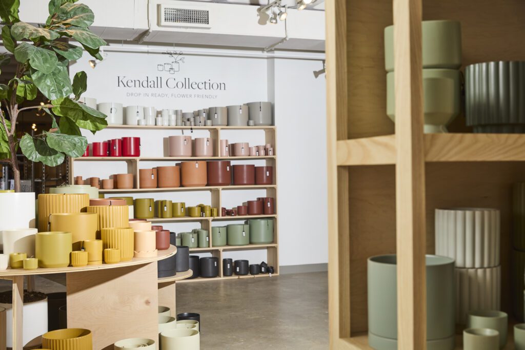 Image of colorful planter pots, including the Kendall Collection, on a variety of tables & shelves.