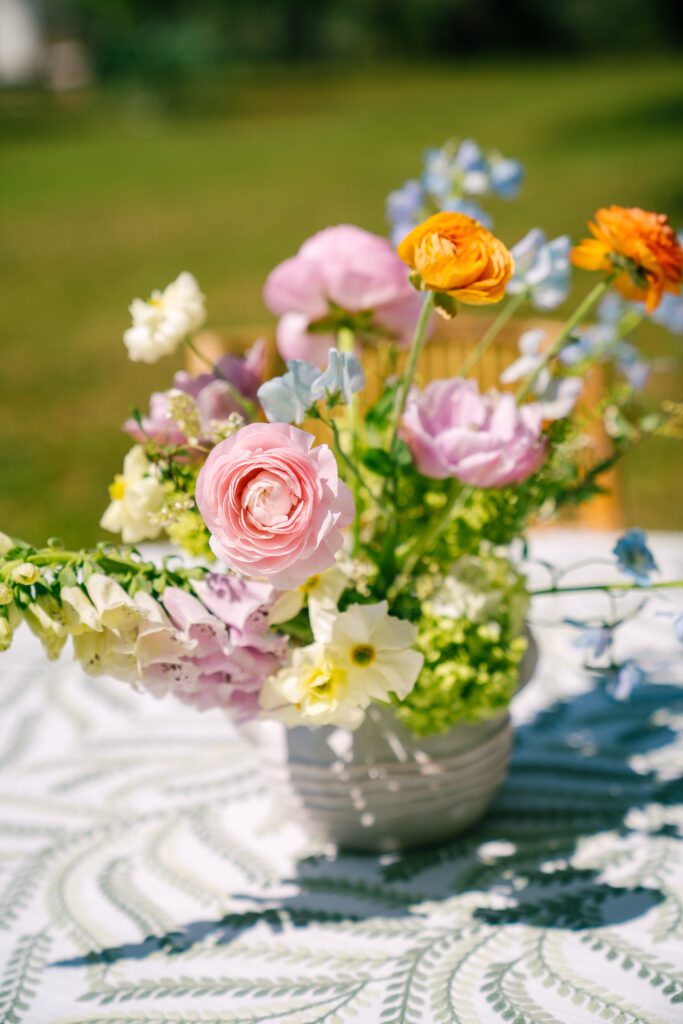 An event tabletop styled outdoors with fresh, colorful flowers.