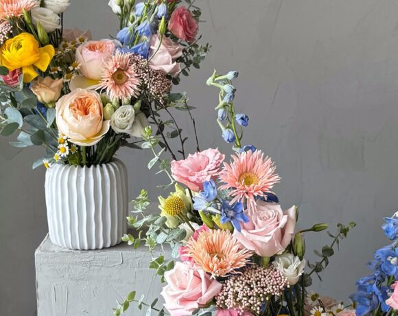 Lush and colorful floral arrangements atop podiums.