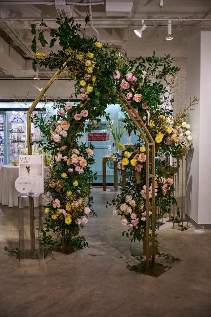 Large arch decor wedding ft. lush yellow and pink florals within the Accent Decor showroom. 