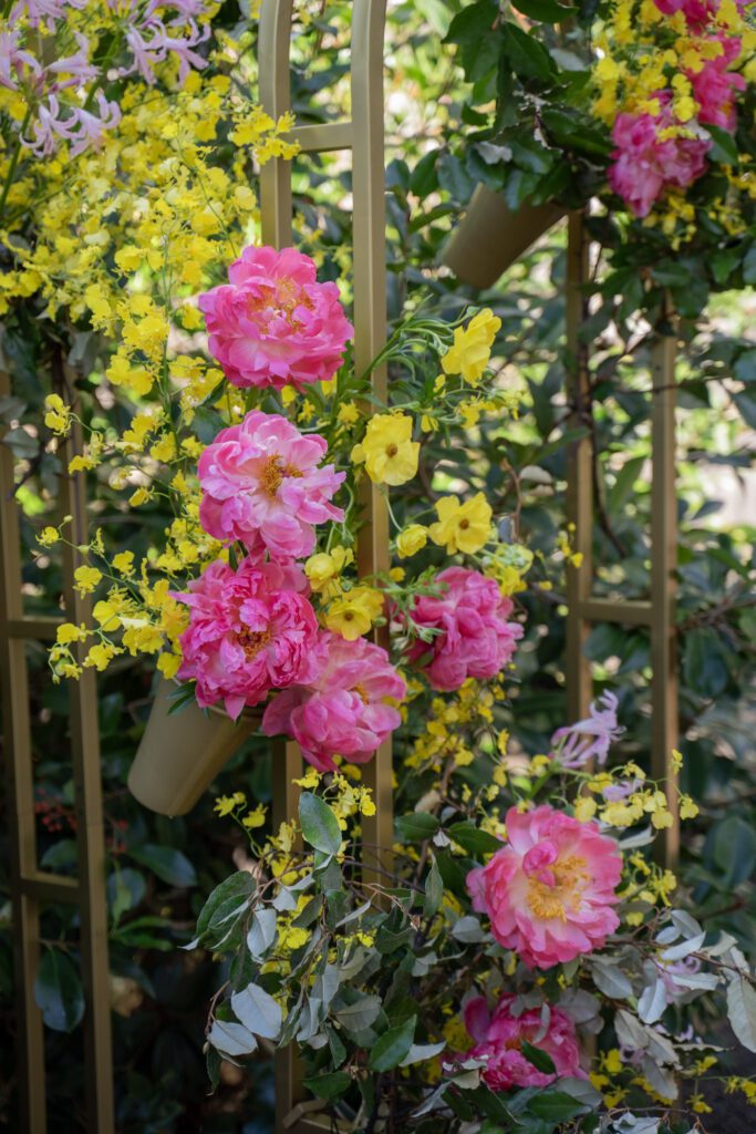 Large arch wedding decor, the Melora Arch, styled with lush flowers in pink, yellow and green.