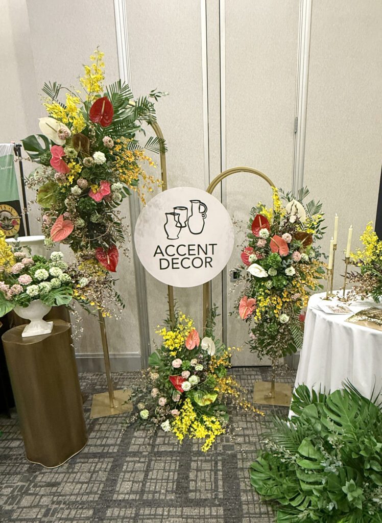 Large arch wedding decor, the Melora Arch, styled with lush tropical florals in shades of green, yellow & red.