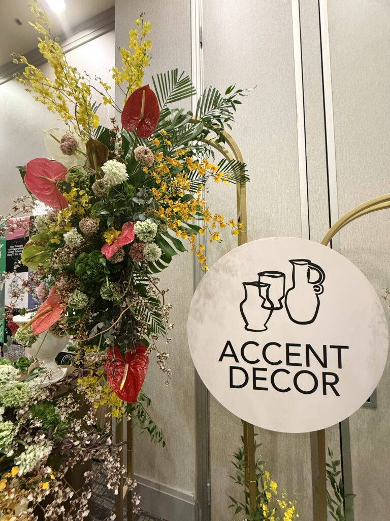 Large arch wedding decor, the Melora Arch, styled with lush tropical florals in shades of green, yellow & red.