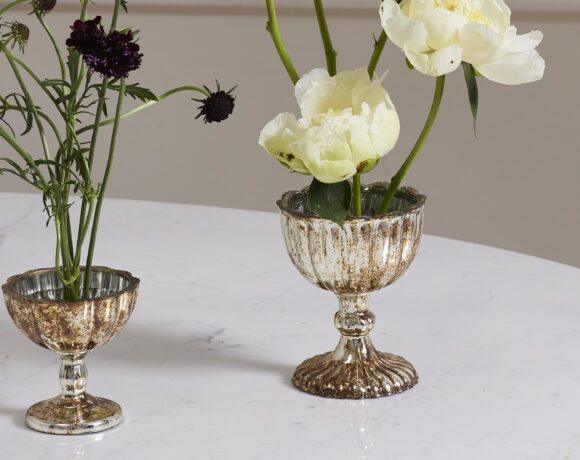 Two metallic silver compotes atop a table